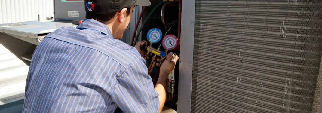HVAC technician servicing a condenser unit in Dodgeville