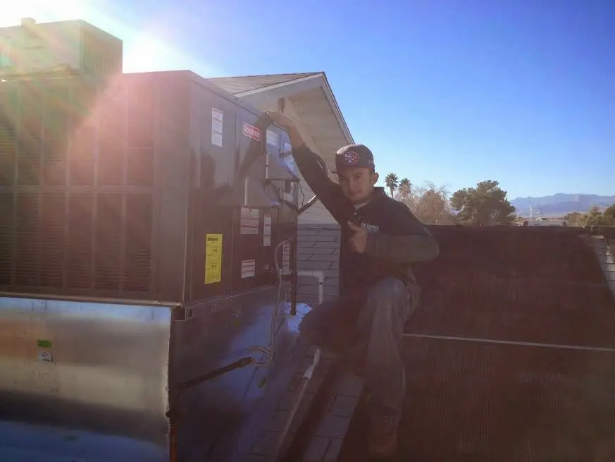 HVAC technician performing AC Tune-Up on a rooftop unit in Dodgeville